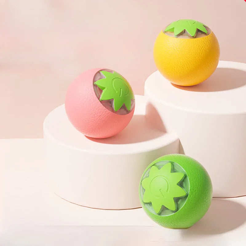 Electric rolling ball toy for dogs and cats in green, pink, and yellow on a light background