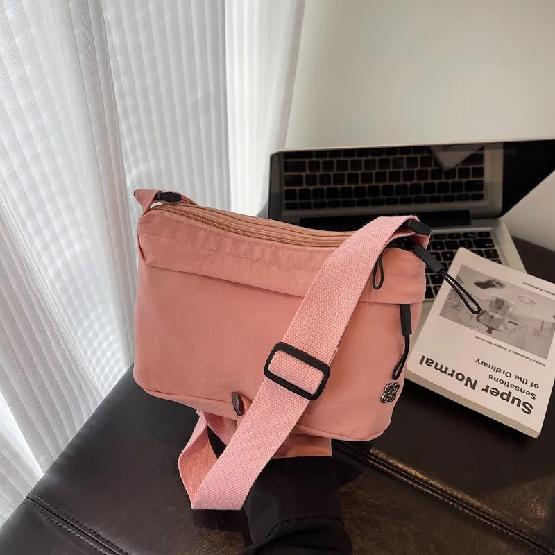 Lightweight cloth crossbody bag in black with horizontal square shape, sandwich pocket, and canvas lining