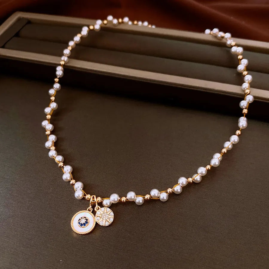 Gold electroplated necklace with round imitation pearl pendant and zircon accents on clavicle-length chain