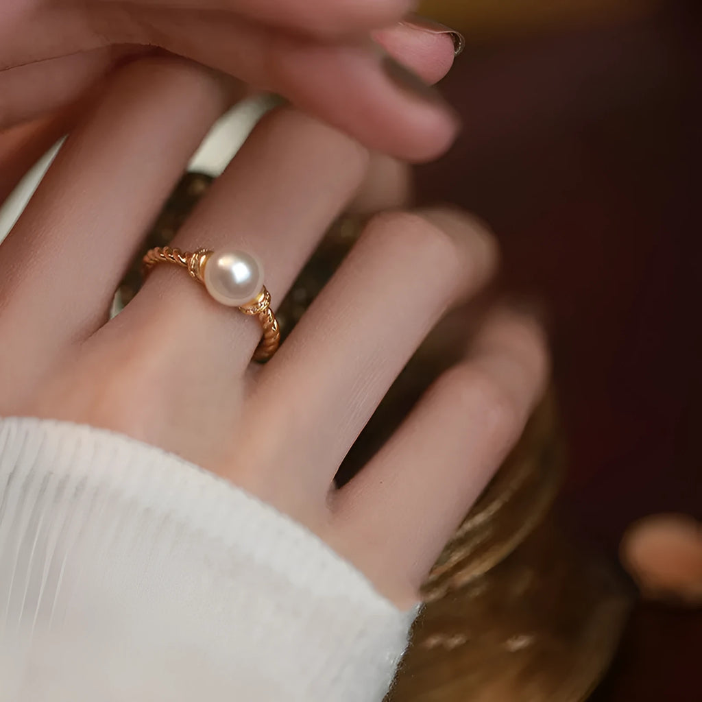 Adjustable antique-style copper ring with a geometric shape and an inlaid pearl, shown in gold and silver colour options.