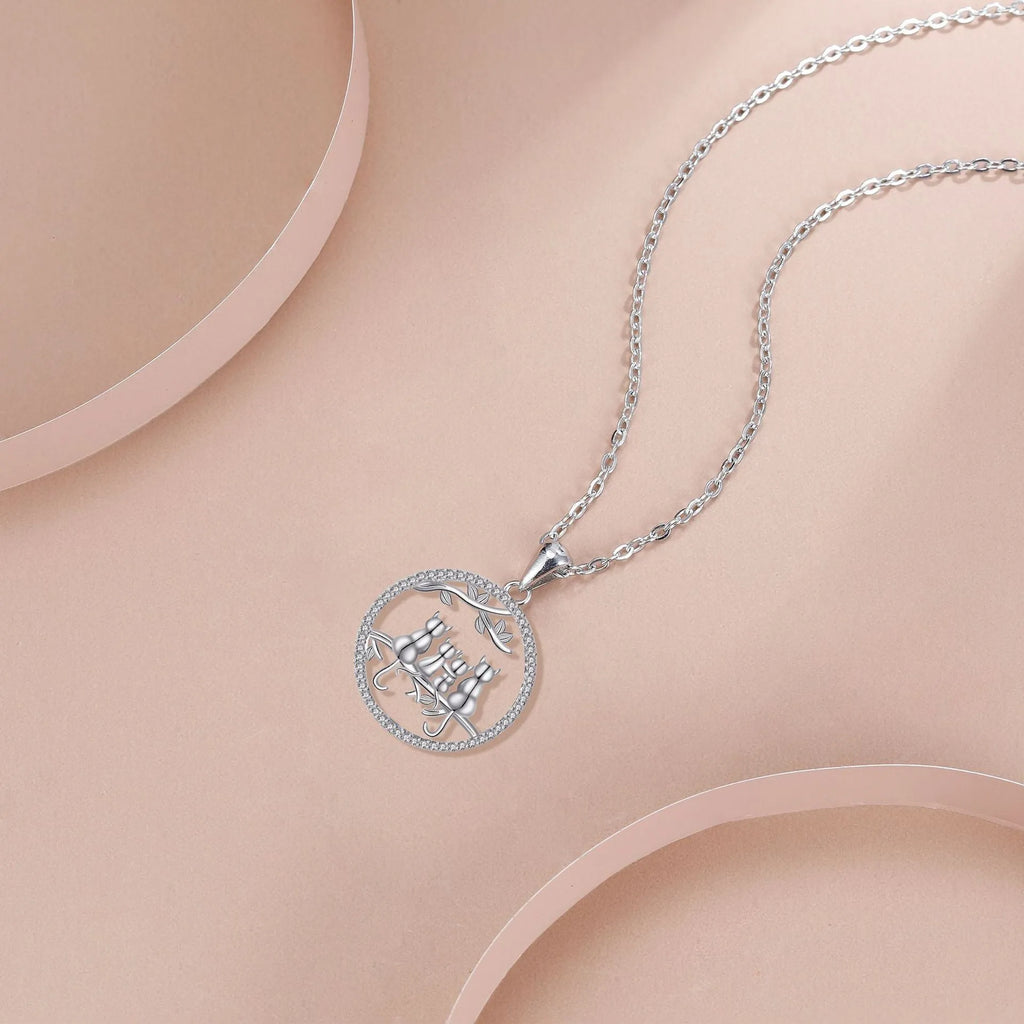 Close-up of a copper necklace featuring a pendant with four kittens in an original design, on a cross chain.