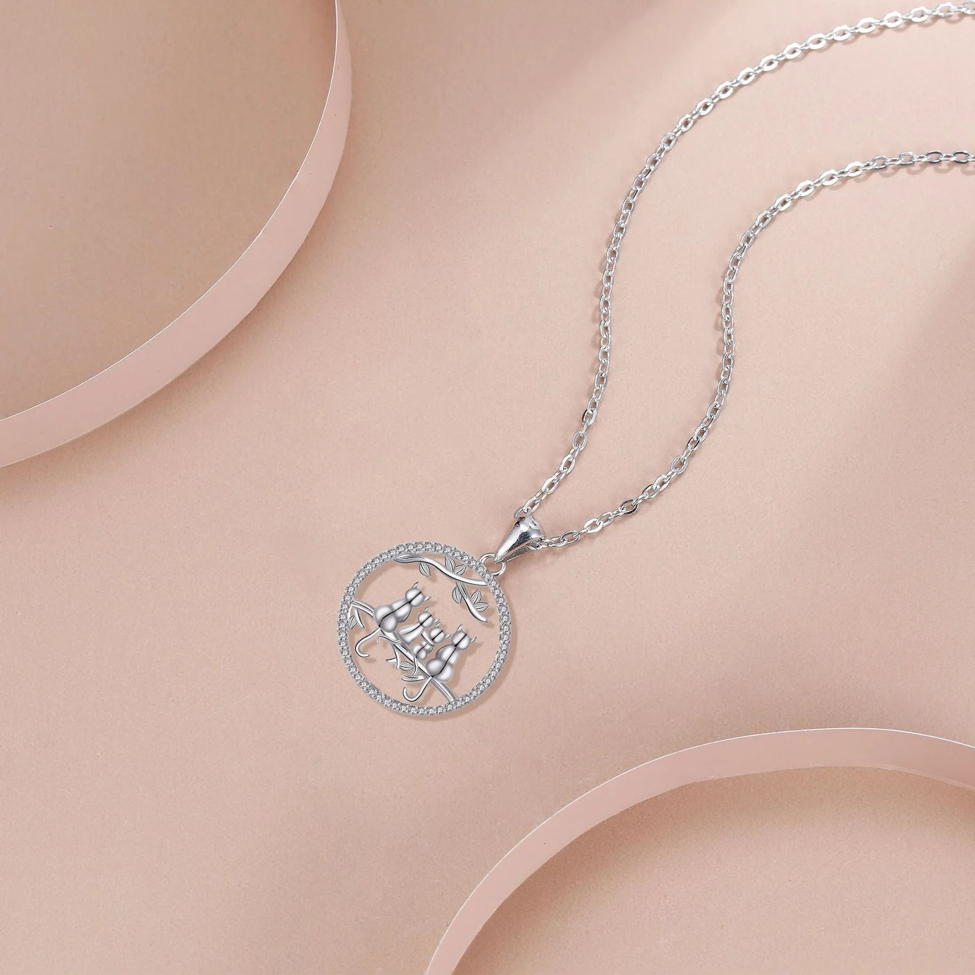 Close-up of a copper necklace featuring a pendant with four kittens in an original design, on a cross chain.