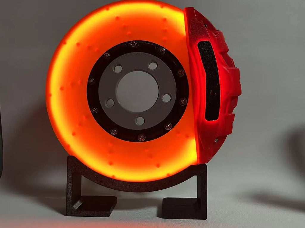 Rechargeable brake disc LED night light with touch dimmer, blue caliper colour, on a desk