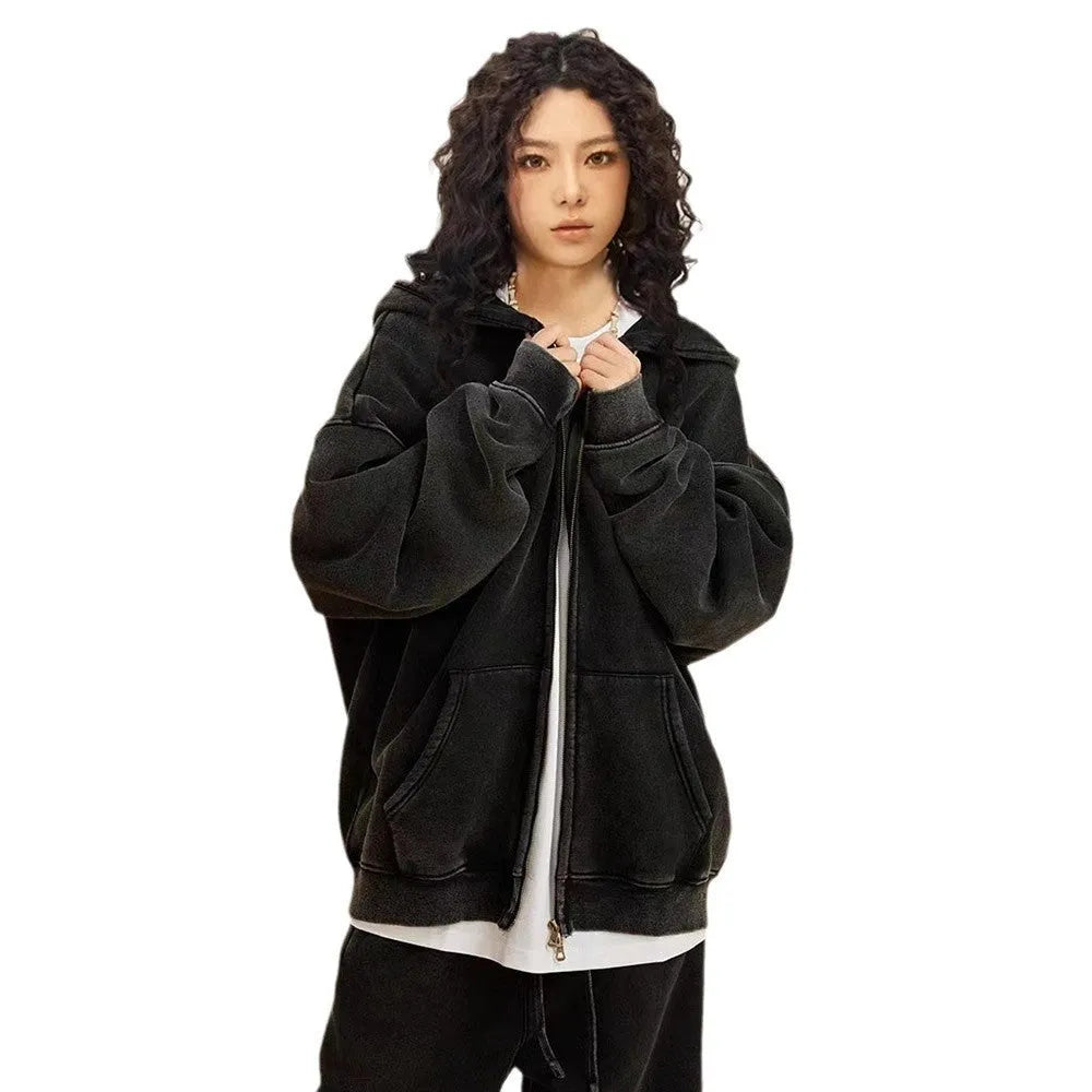 Man wearing a vintage washed dark green hooded cardigan with a double zipper and fleece lining.