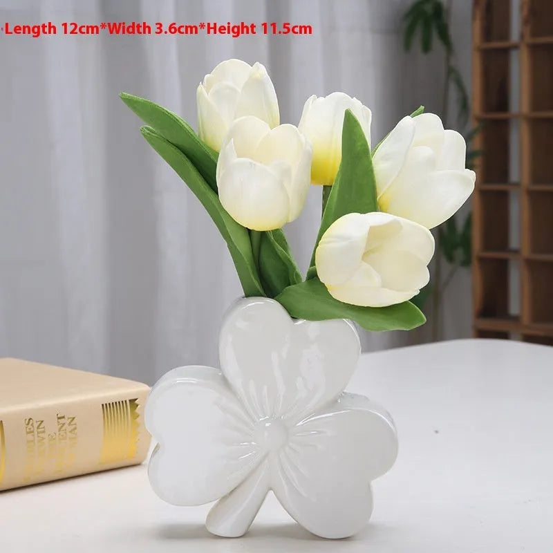 White porcelain clover ceramic vase in European style on a desktop.