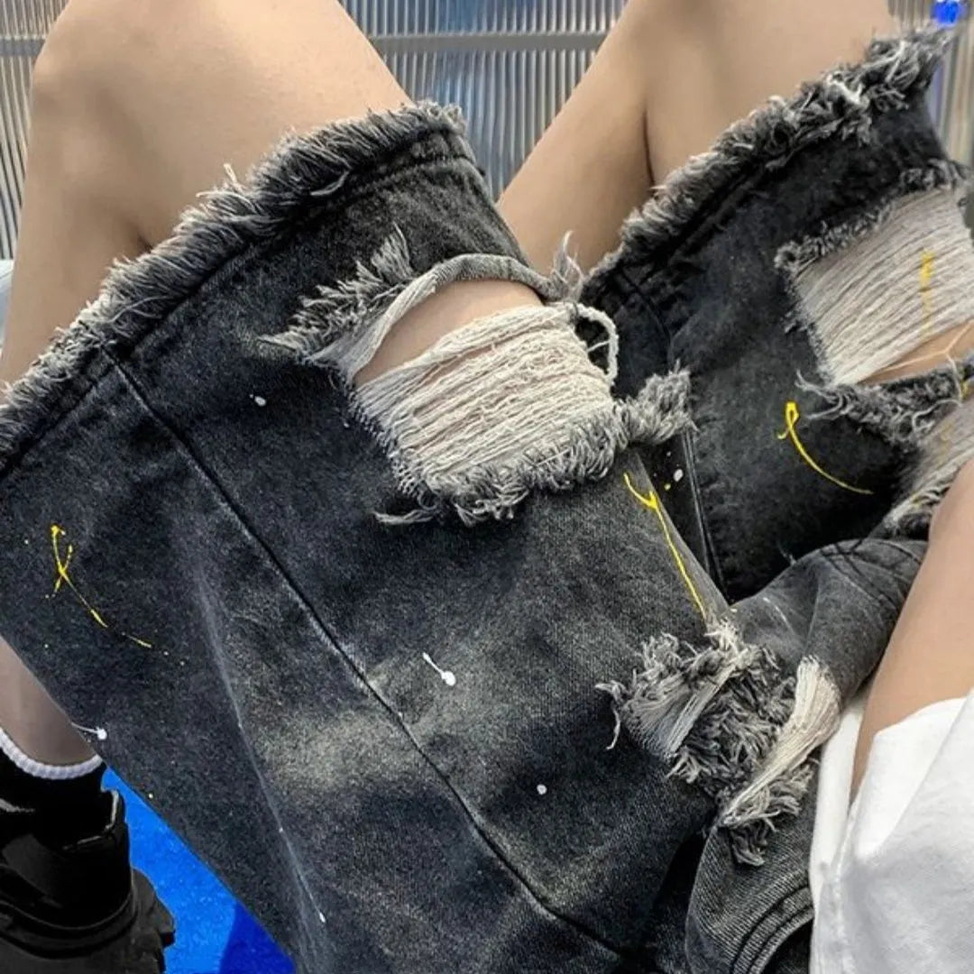 Men's loose fit denim shorts in light blue with water washed hole detail, laid flat.