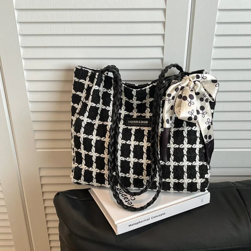Black woven wool shoulder bag with horizontal square shape showing internal organiser compartments