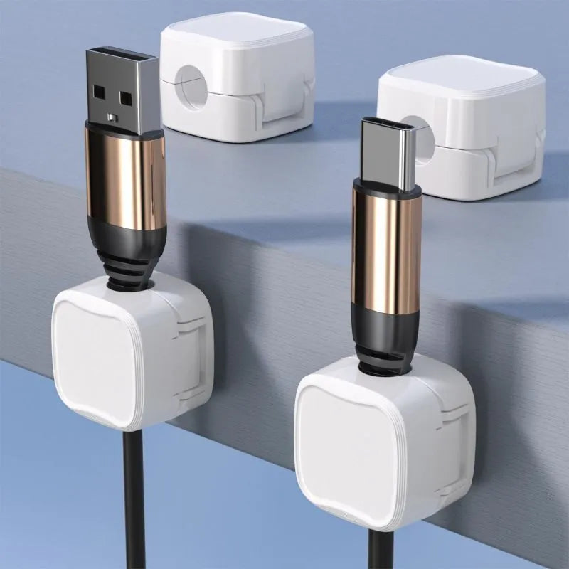 Magnetic cable clip in white holding a USB cable under a desk, with adhesive backing visible
