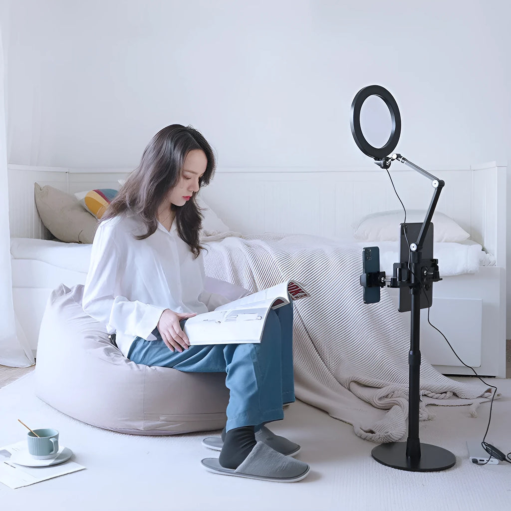 Black aluminium alloy and ABS mobile phone tablet stand with built-in fill light, folded vertical orientation on a table