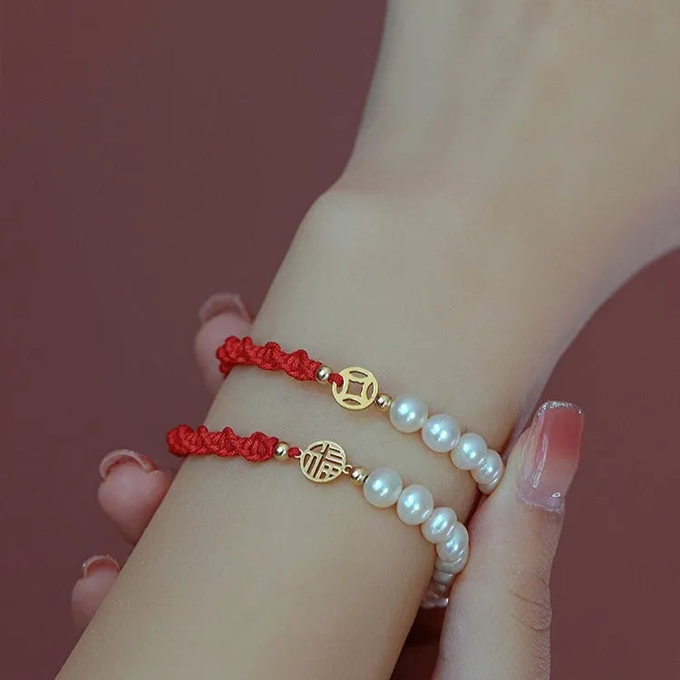 Women's pearl braided red rope bracelet with domestic 14K gold plated fu character charm on red background
