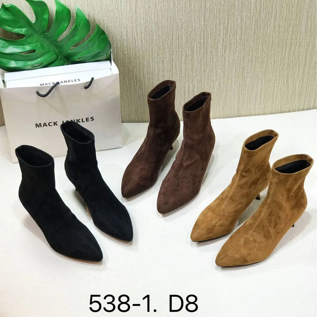 Black pointed toe ankle boots with a stiletto heel on a white background