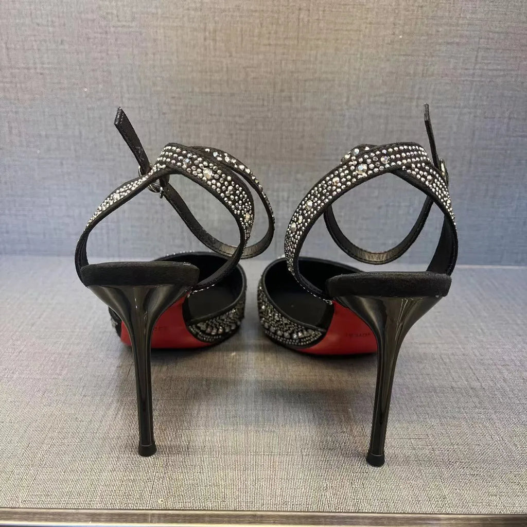 Women's black high heel shoe with pointed toe, stiletto heel, red sole, and hollow design detail.