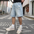 Light blue ripped denim shorts with distressed detailing and loose straight leg fit