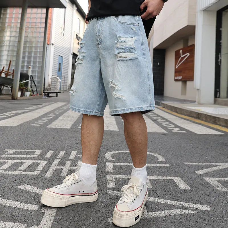 Light blue ripped denim shorts with distressed detailing and loose straight leg fit