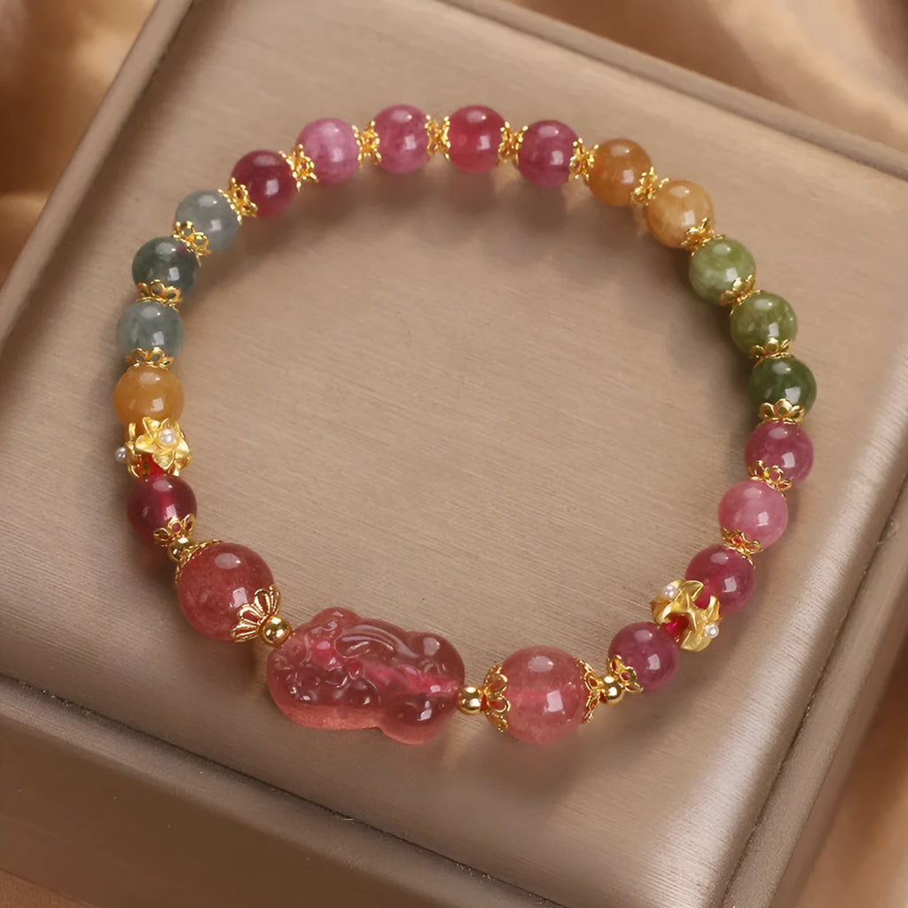 Pink crystal Pi Xiu bracelet with tourmaline and strawberry quartz beads on white background