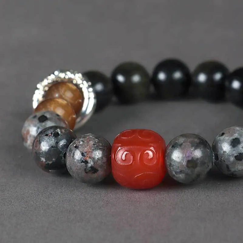 Gold obsidian flame stone and red agate unisex bracelet with original Wukong design on neutral background