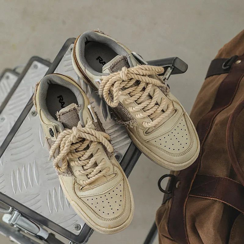 Beige low top skateboard shoes with rubber sole and front lace-up design