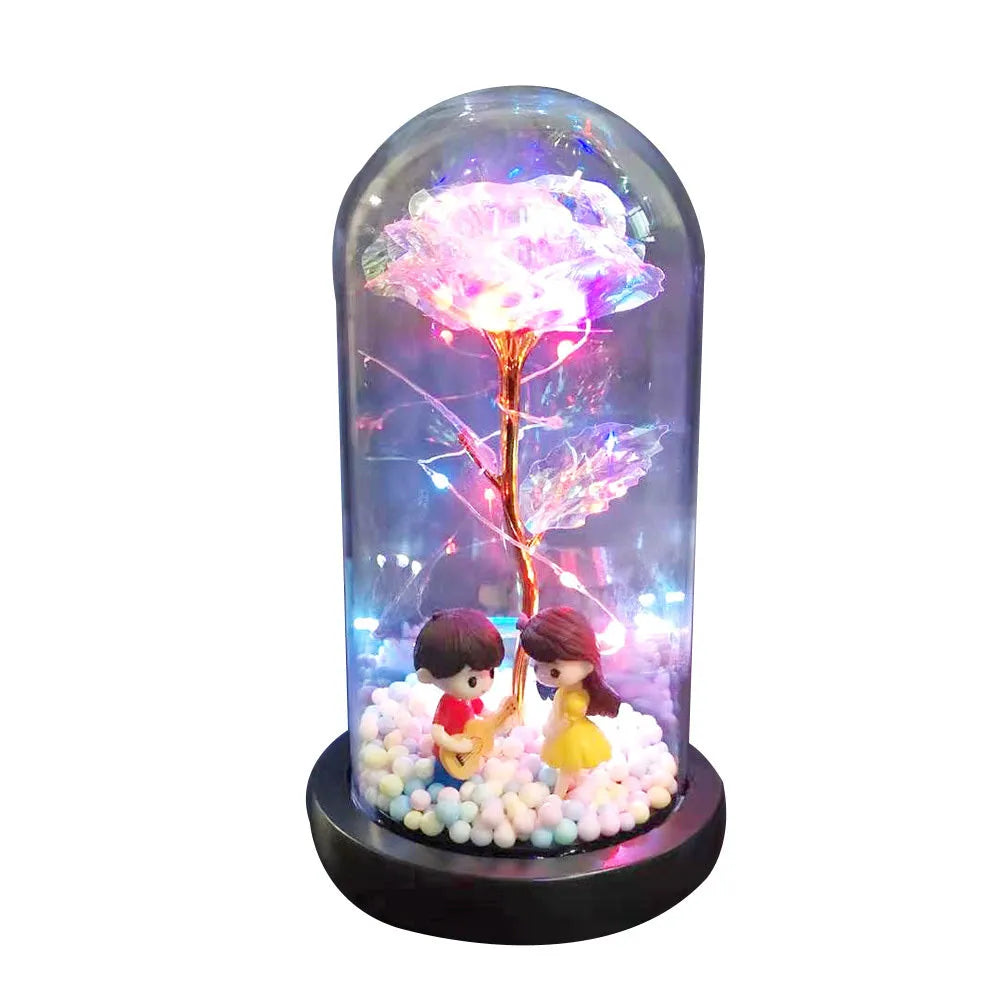 Gold artificial rose inside glass dome with LED lights on black base for home display