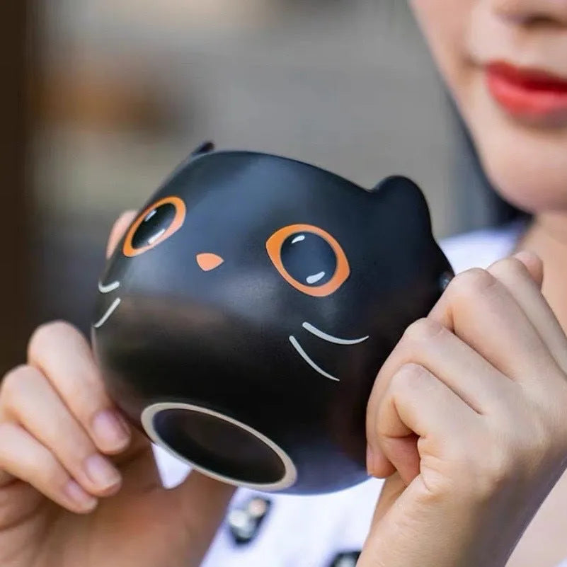 Black ceramic cat-shaped mug with pumpkin covered spoon on side