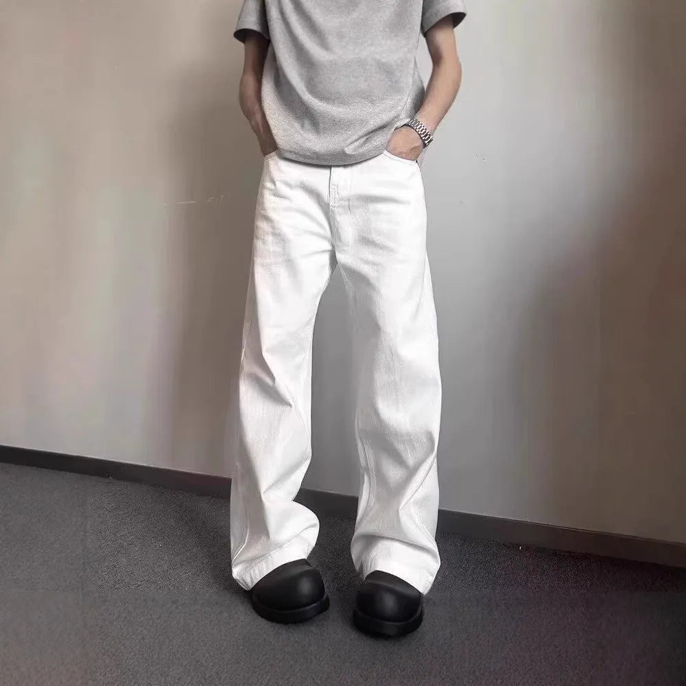 Men's white loose fit straight-leg cotton denim jeans on a plain background.
