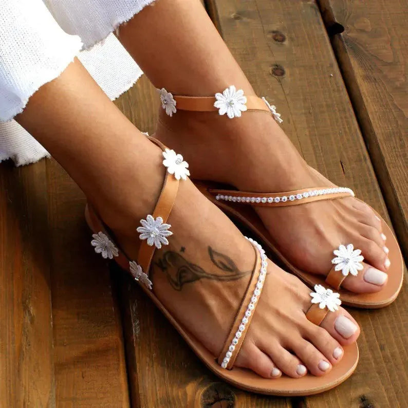 Brown ladies Roman sandals with floral decoration on PU upper and flat rubber sole