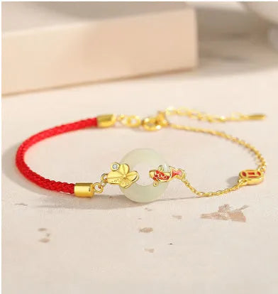 Gold 925 silver koi peace buckle bracelet with red rope on white background