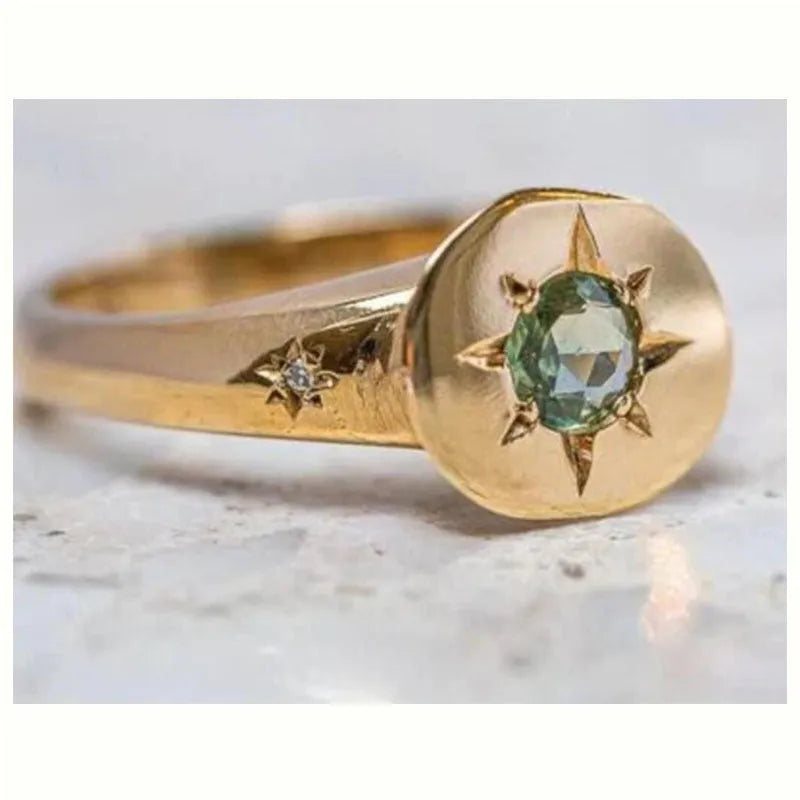 Gold coloured adjustable ring with a star-shaped zircon centre on a zinc alloy band.