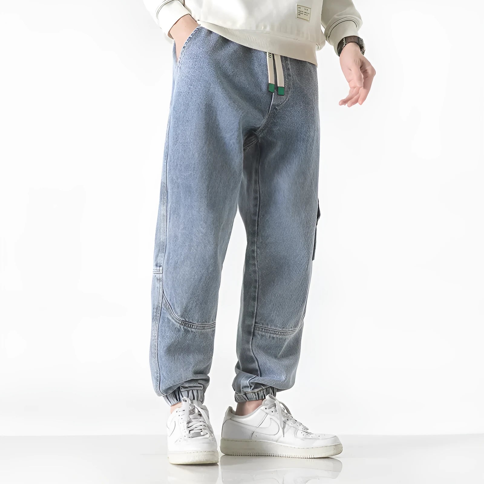 Men's loose-fit tapered cotton trousers in grey shown flat, with mid waist and tapered leg detail.