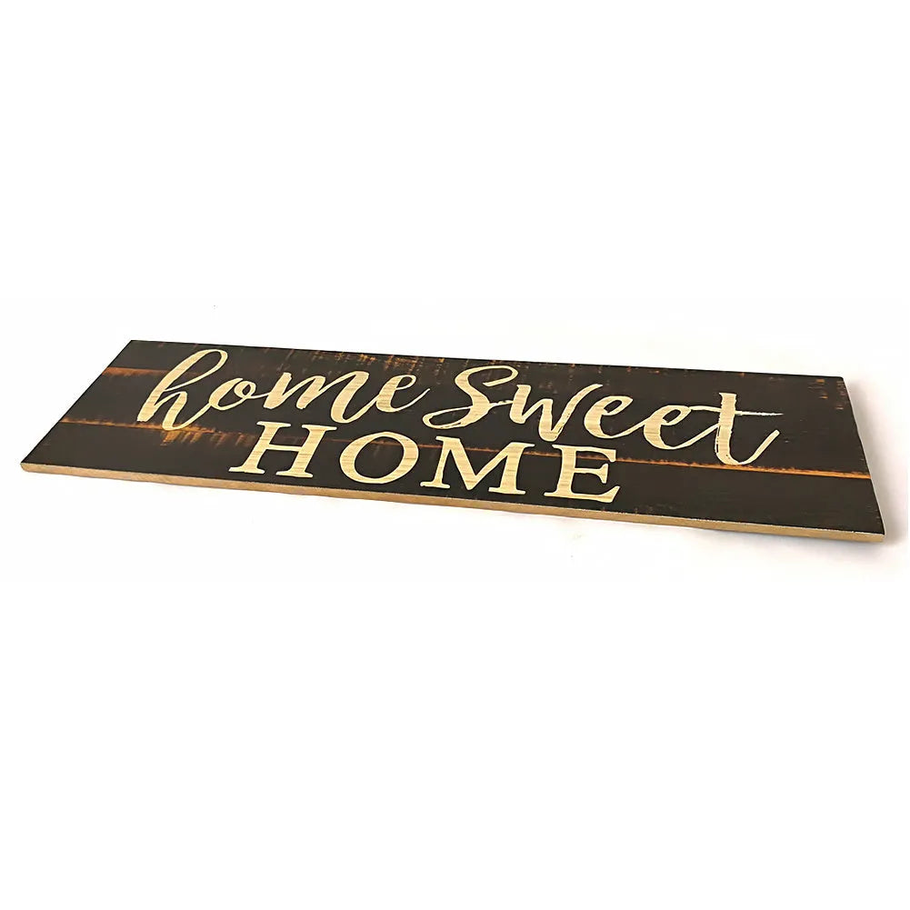 Home Sweet Home wooden carved pendant in black, 40cm x 12cm, hanging on a light wall