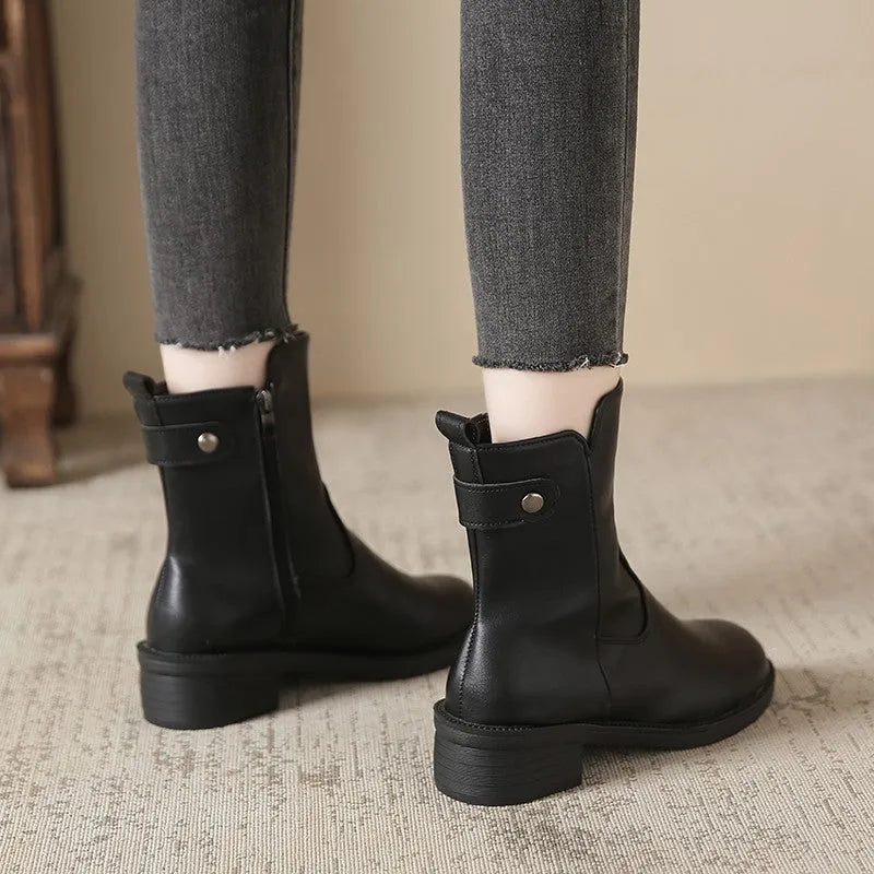 Black women's ankle boots with side zip, round toe, and low rubber sole