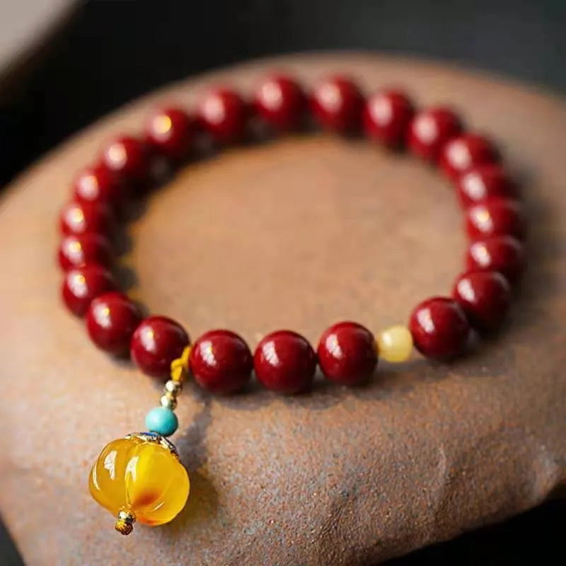 Handmade wave-shaped bracelet featuring cinnabar and copper beads on a wrist.