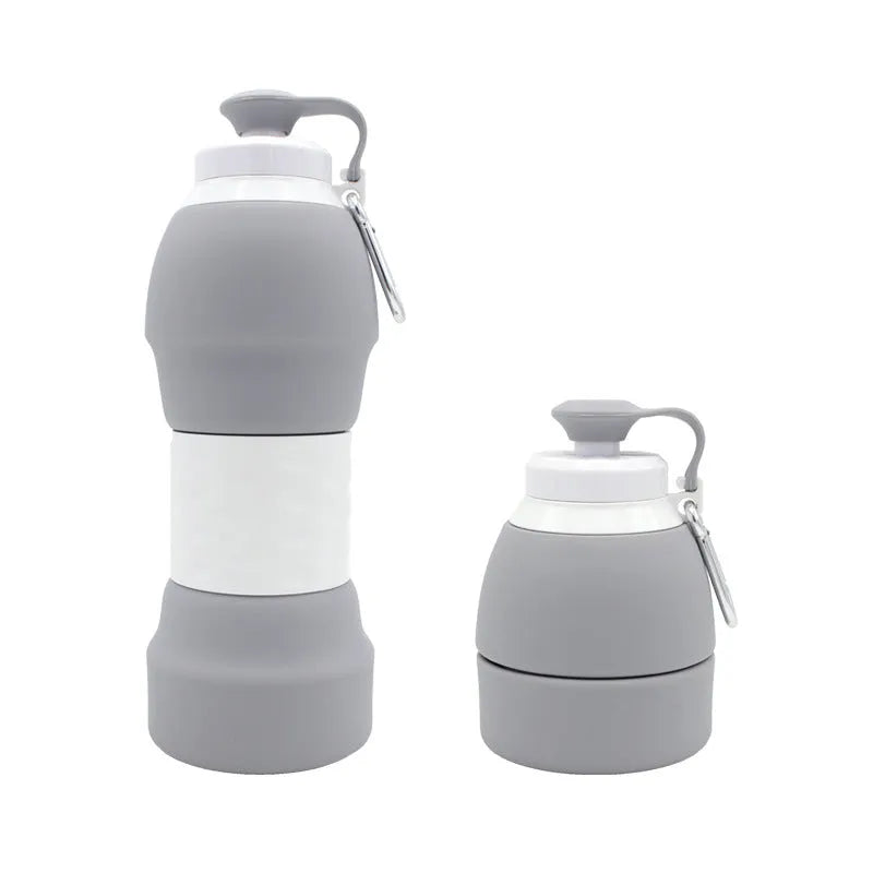 Silicone folding water bottle 580ml in blue, collapsed and full size, with cap, on outdoor background