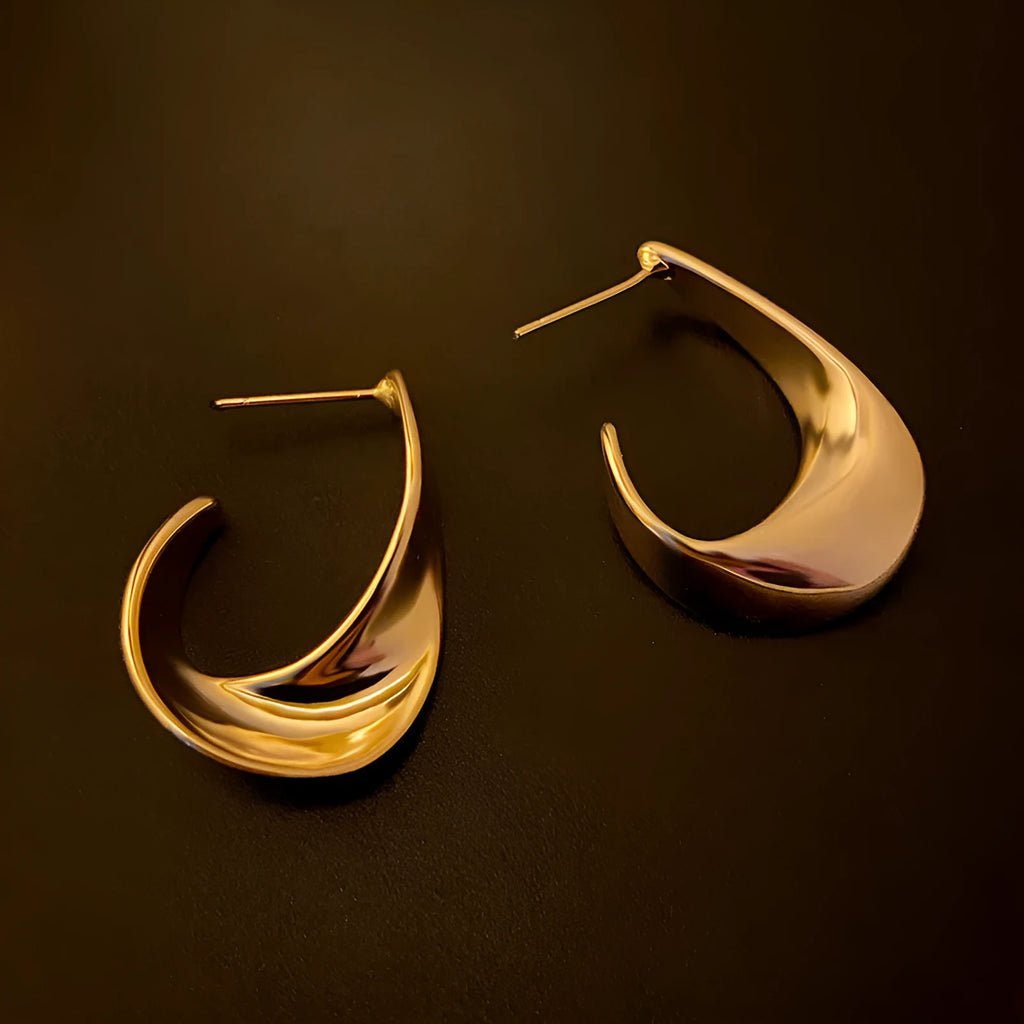 Gold twisted geometric metal earrings with round design elements