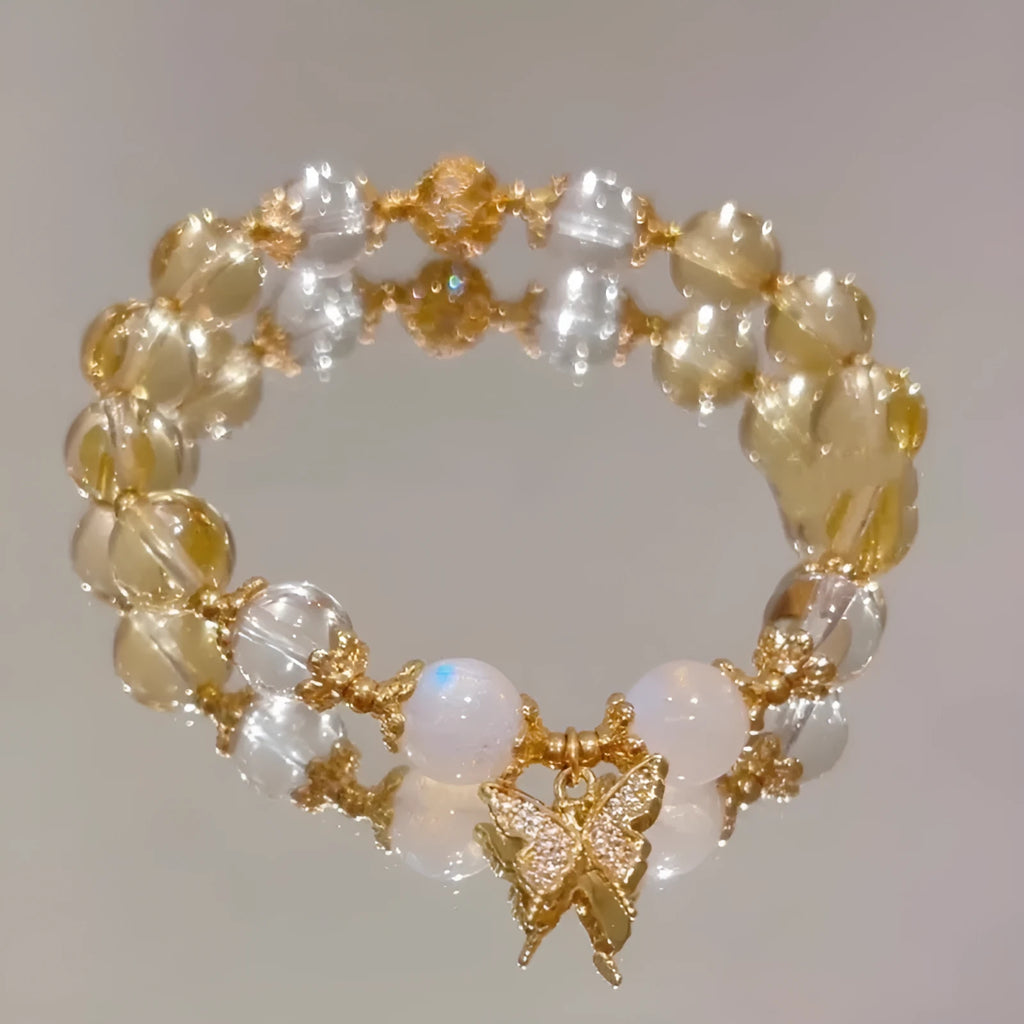 Moonstone white crystal beaded bracelet with citrine butterfly pendant on a white background
