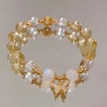 Moonstone white crystal beaded bracelet with citrine butterfly pendant on a white background