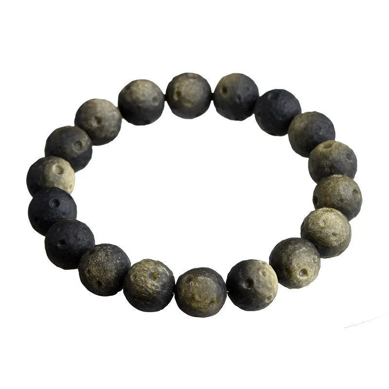 Natural obsidian crater ball bracelet in gold or silver meteorite finish on a wrist.