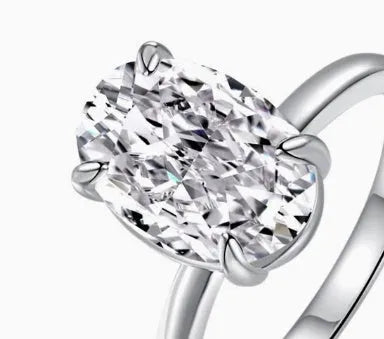 Oval solitaire ring in sterling silver with a four-prong setting and a central gemstone.