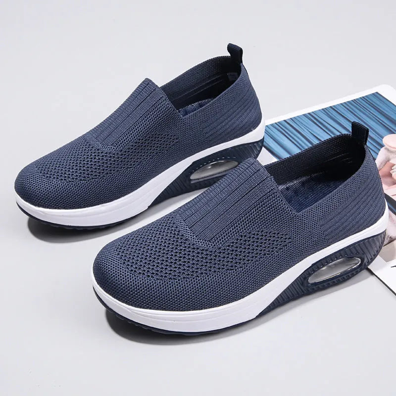 Women's beige mesh running shoes with air cushion midsole on a neutral background.