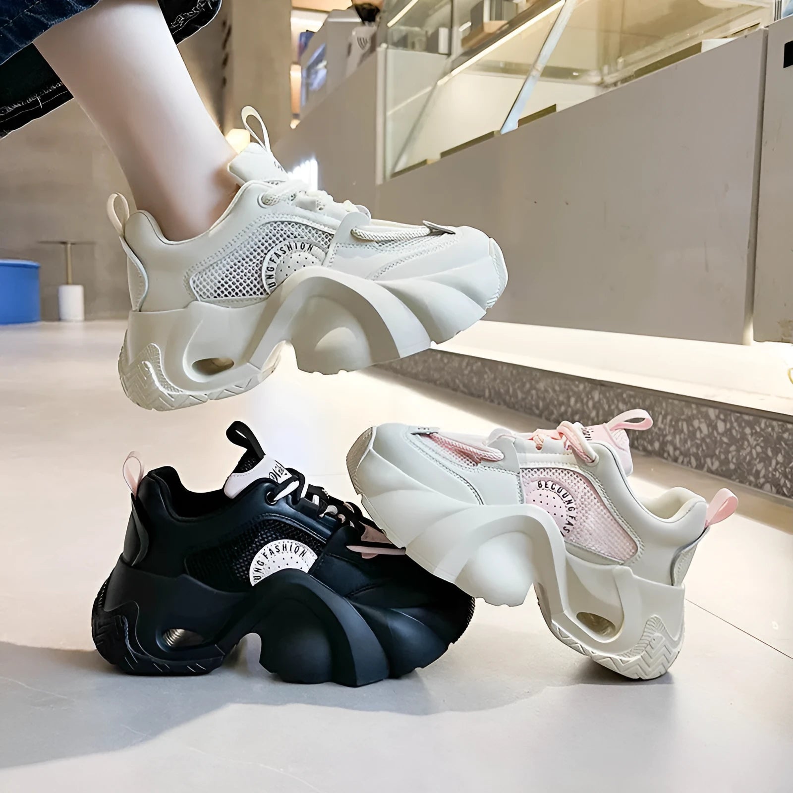 Women's pink sneakers with cross shoulder straps, thick platform sole, and breathable mesh lining.