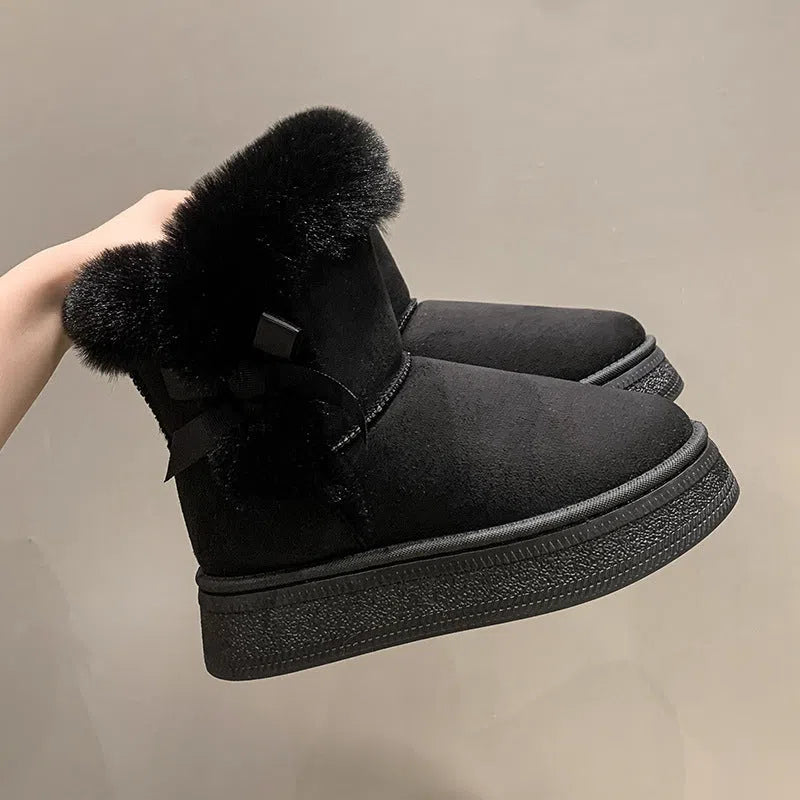 Women's mid-calf fleece-lined snow boots in brown with black rubber sole and bow tie detail