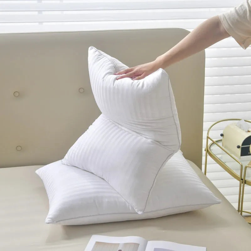 White cotton satin stripe pillow with feather and cotton filling shown in adult bedding setting.