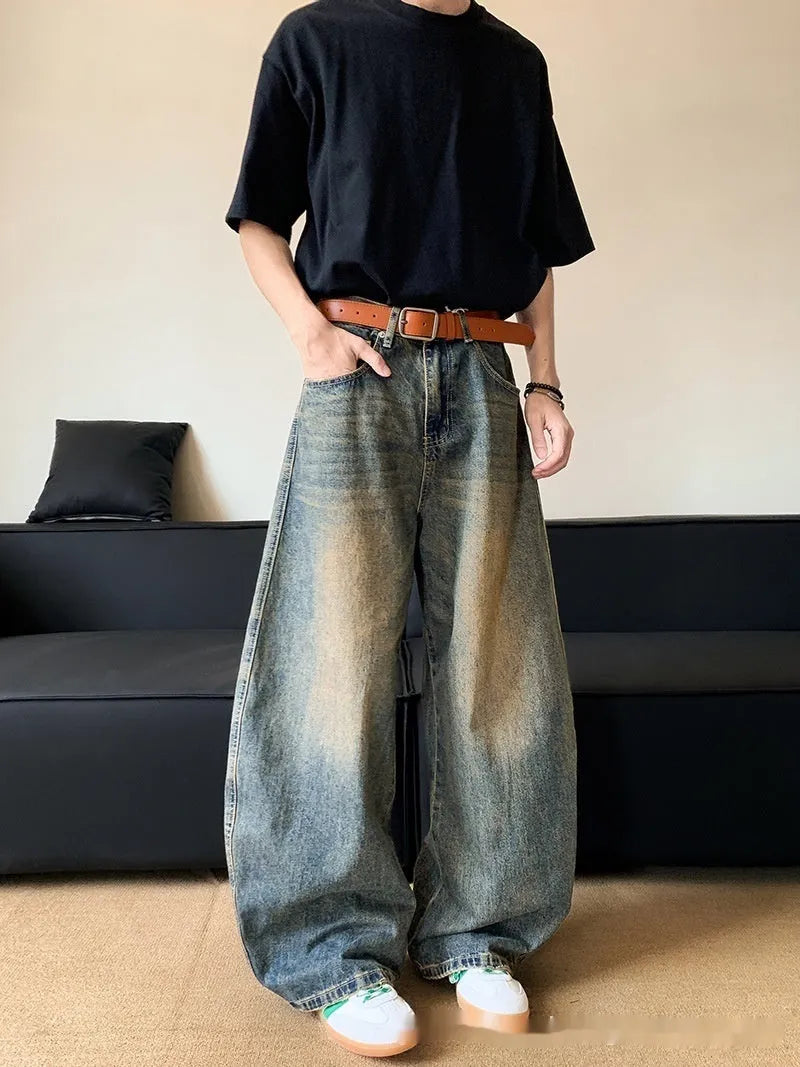 Man wearing retro blue distressed denim wide-leg trousers with a slim fit and zipper fly