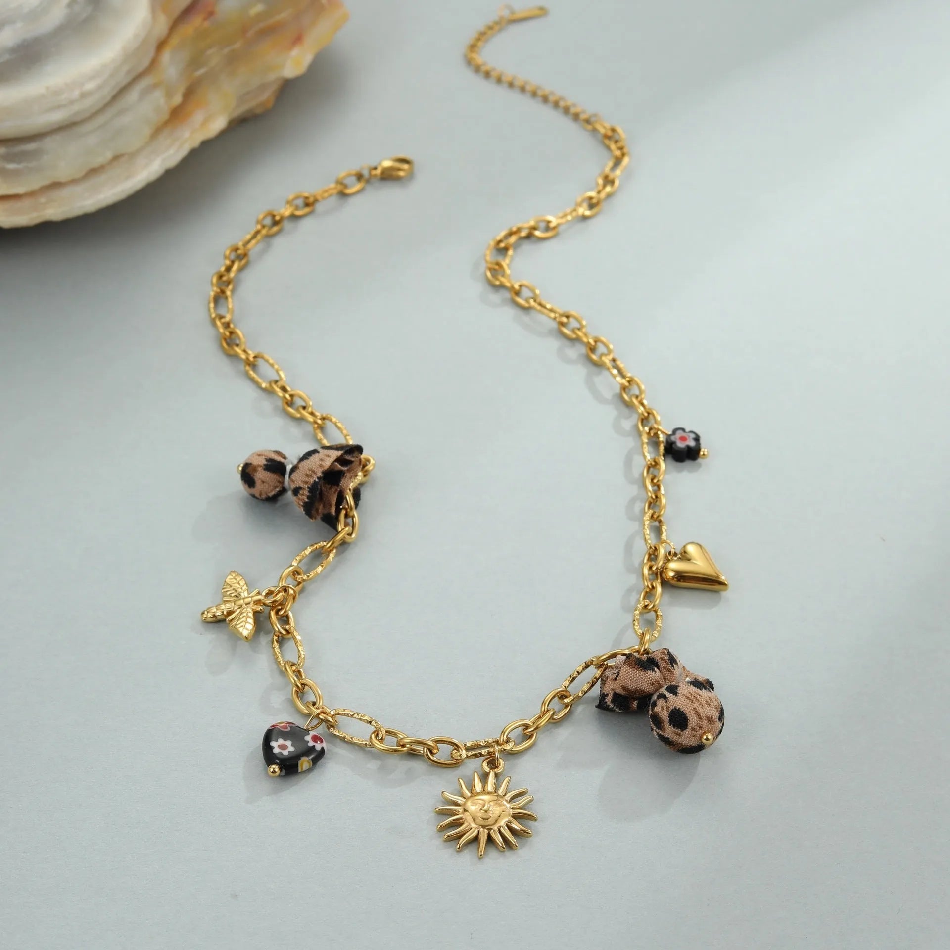 Geometric stainless steel necklace with leopard, heart and flower motifs on 18K electroplated pendant