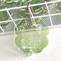 Four-leaf clover shaped acrylic pendant keychain in mint green colour on a surface