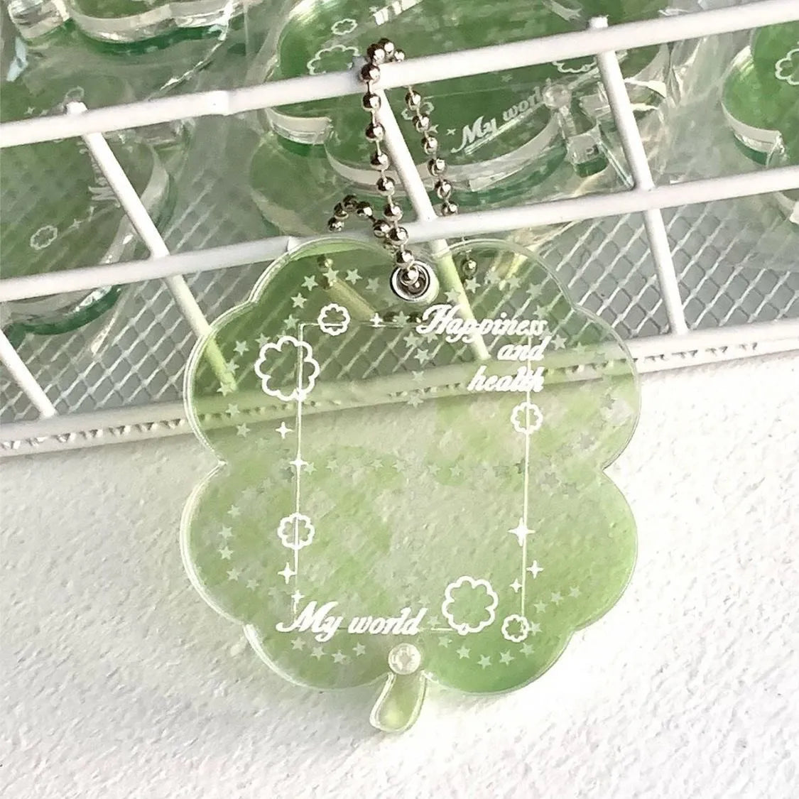 Four-leaf clover shaped acrylic pendant keychain in mint green colour on a surface