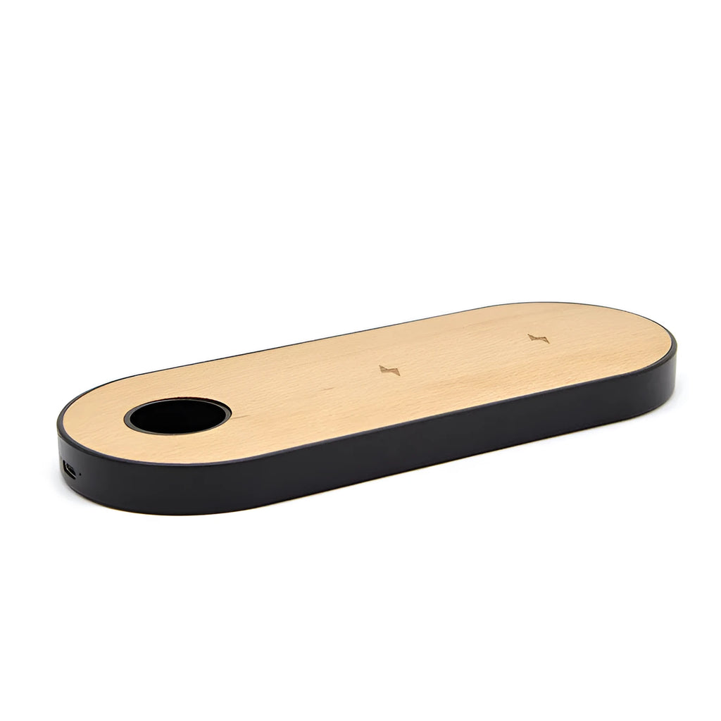 Wooden wireless charger with natural bamboo surface and walnut edging on a desk