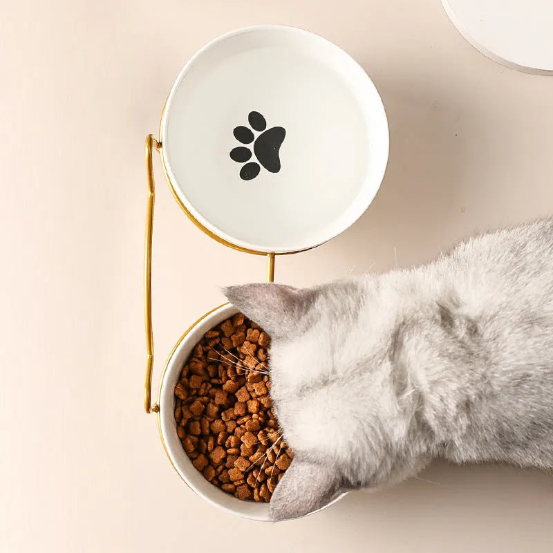 White ceramic cat bowl with cat footprint design in a black iron frame with cat ears.
