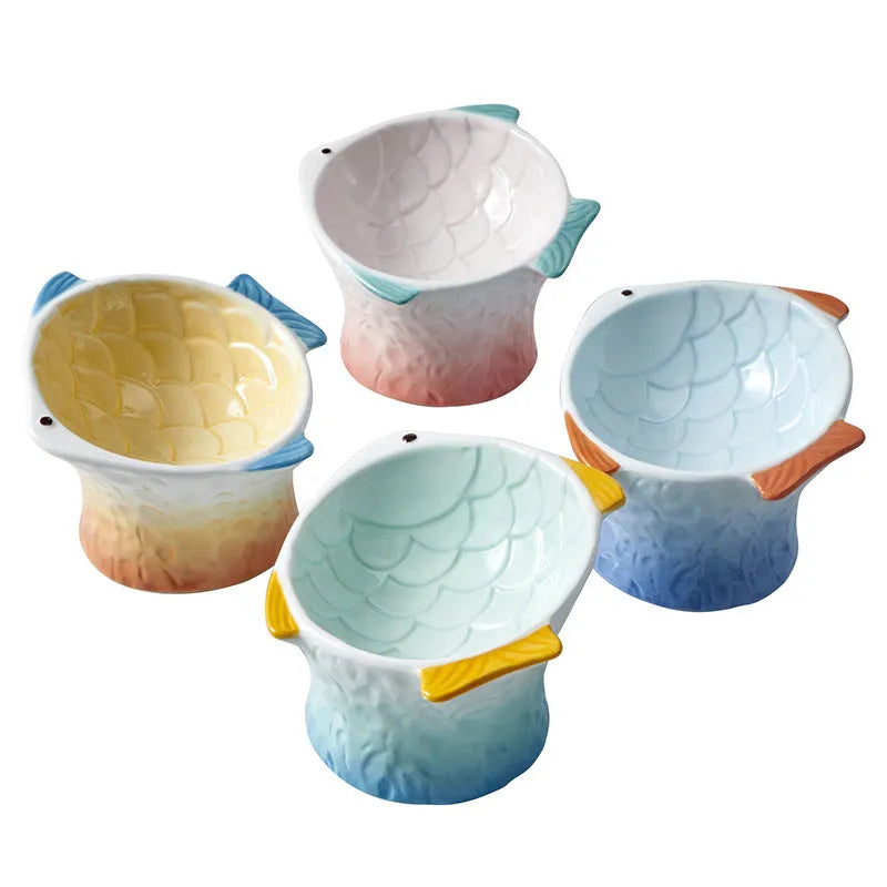 Blue ceramic fish-shaped cat feeder bowl with a tilted, elevated design on a non-slip base.