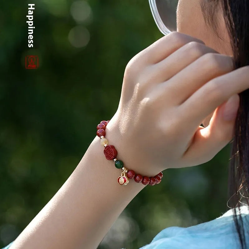 Happy eyebrow bracelet with emperor sandstone beads and a central carved fu charm on a string.