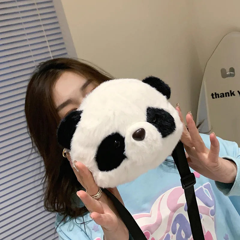 Soft plush crossbody bag with panda head design, cylindrical shape, and outer pocket.